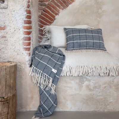 Coussins frangés en laine- Modèles SHAKO SHAKER, coloris écru. Plaid et coussin en lin - Modèles CACAO et CANYON, coloris denim