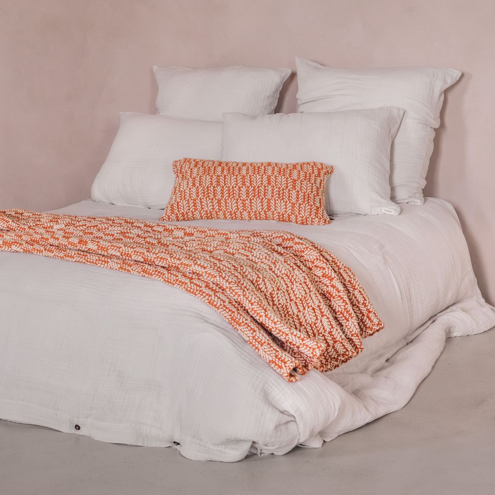 Coussin de décoration en laine à motifs contrastés 30x60cm et plaid Camillo, coloris carmin, thème scandinavia, sur un lit avec la housse de couette DOLLAR, les taie d'oreiller DONA et DOLBY en coloris plume, mélange de lin et coton