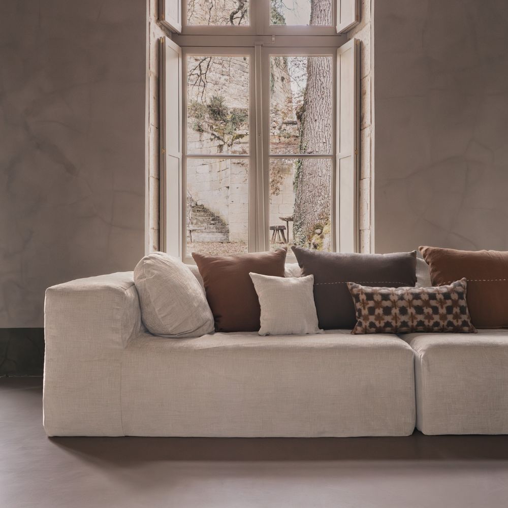 Coussin bi-matière zia 30x60cm face motif avec, coussin bi-matière ziggy 30x30 face unie, thème Refuge & Flowers, devant coussin en lin copper 50x70cm coloris vetiver, alezan et bisont thème Farm Life sur canapé 4 places en velours chenille slow family coloris Amande