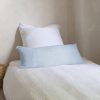 Coussin en lin 30x70, modèle uni, SMOOTHIE, brut- coloris Aqua sur un lit simple avec une parure de lit blanche