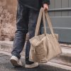 Sac week-end en cuir, à longues anses, porté par un homme, TRIP, coloris Greige, thème Velvet Leather, zoom sac