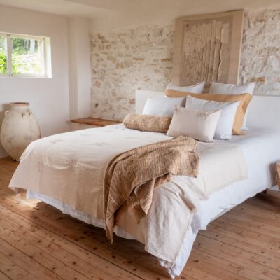 Coussin DOMINGO et plaid DONATO en coton DOMINGO, coloris Natural, thème Douce Hacienda, avec coussin en lin 55x110cm Crush, coloris Honey thème FARM LIFE, coussin GISELE et plaid GARANCE en soie coloris miel thème Soie/Solar sur un lit