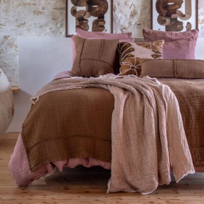 Plaid en triple gaze de coton et finition frangée, Portovecchio, coloris Sunset, thème Fresh, sur lit avec plaid en coton NATTE, coussin 50x50cm NAXOS et coussin 30x60 NIRVANA, coloris Café et coussin à motifs fleuris TAARI sur du linge de lit en lin et coton en coloris Rosebud