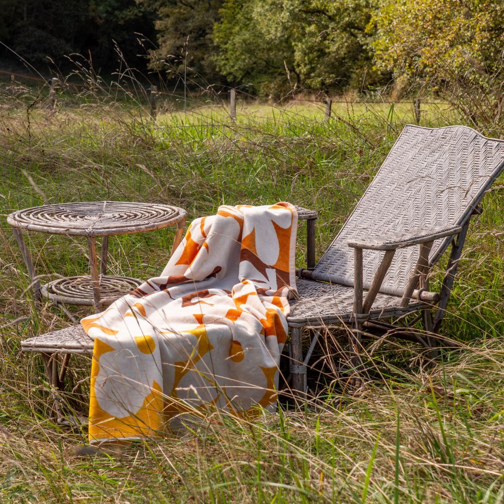 Serviette de bain ou de plage en éponge 550g à motifs fleuris ambiance 70s, DOLL, coloris Spritz, thème Tulum, sur une chaise-longue