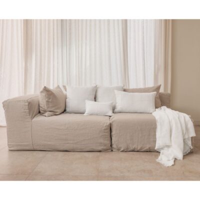 Coussins en lin HECTOR 40x60cm, HORACE 50x50cm, HYPOLITE 25x40cm, coloris WHITE, thème HANDMADE, avec coussin CROSS et plaid COMEBACK en lin, coloris Snowy, thème FARM LIFE, sur canapé en lin coloris Naturel, ligne SLOW, module d'angle COIN et chauffeuse SOLO