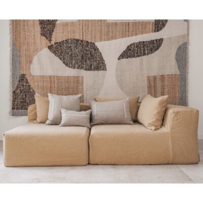 Coussins en lin HECTOR 40x60cm, HORACE 50x50cm, HYPOLITE 25x40cm, coloris NATUREL, thème HANDMADE, tapis BOHEMIAN âme philo en tenture murale, sur canapé en lin coloris SAVANE, ligne SLOW, module d'angle COIN et chauffeuse SOLO