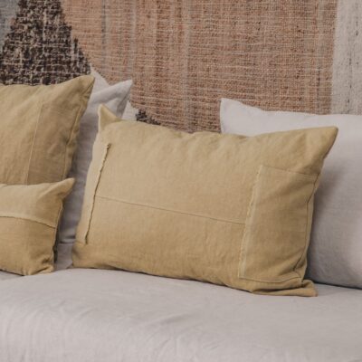 Coussins en lin HECTOR 40x60cm, HORACE 50x50cm, HYPOLITE 25x40cm, coloris SAVANE, thème HANDMADE, tapis BOHEMIAN âme philo en tenture murale, sur canapé en lin coloris CHALK, ligne SLOW, module d'angle COIN et chauffeuse SOLO
