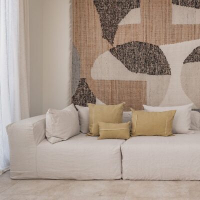 Coussins en lin HECTOR 40x60cm, HORACE 50x50cm, HYPOLITE 25x40cm, coloris SAVANE, thème HANDMADE, tapis BOHEMIAN âme philo en tenture murale, sur canapé en lin coloris CHALK, ligne SLOW, module d'angle COIN et chauffeuse SOLO