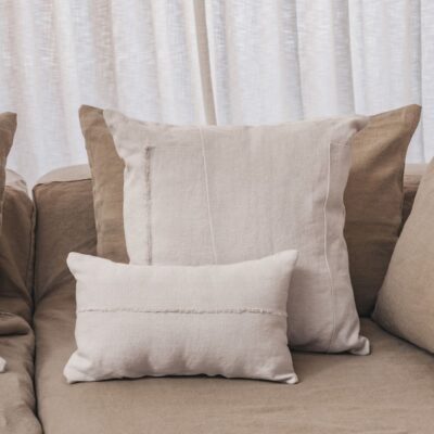 Coussins en lin HECTOR 40x60cm, HORACE 50x50cm, HYPOLITE 25x40cm, coloris CHALK, thème HANDMADE, sur canapé en lin coloris Naturel, ligne SLOW, module d'angle COIN et chauffeuse SOLO