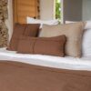 Coussins en coton et lin NIRVANA 30x70cm et NAXOS 50x50cm, et plaid NATTE 140X200CM, coloris Café, thème Couleurs Locales avec coussins en lin COMICS 30x60cm, COPPER 50x70cm et plaid COMEBAKC, coloris Sable, thème FARM LIFE sur linge de lit en lin et coton plume
