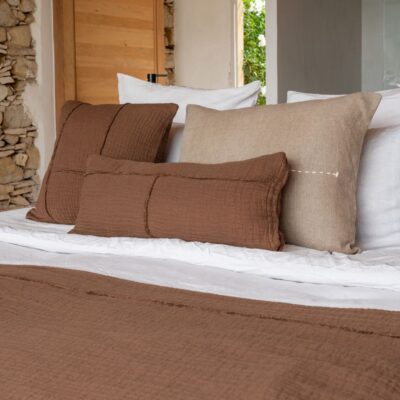 Coussins en coton et lin NIRVANA 30x70cm et NAXOS 50x50cm, et plaid NATTE 140X200CM, coloris Café, thème Couleurs Locales avec coussins en lin COMICS 30x60cm, COPPER 50x70cm et plaid COMEBAKC, coloris Sable, thème FARM LIFE sur linge de lit en lin et coton plume