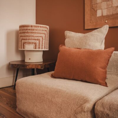 Canapé en lin Grosse Trame, module chauffeuse SOLO, ligne SLOW, coussin TAORMINA, coloris Sienna, thème PIGMENTS, lampe VERTIGO en coton tufté avec pied en céramique TERRAM1 âme philo