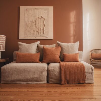 Canapé deux places en lin Grosse Trame, modules chauffeuse SOLO, ligne SLOW, coussins en coton crochet TRIBU, TIERRA, TOTEM et plaid TOBAGO, coloris SIENNA, thème TIERRA DEL SOL, lampe VERTIGO en coton tufté avec pied en céramique TERRAM1 âme philo