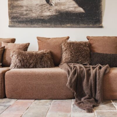 Coussins en fausse fourrure, Faro et Falvie, coloris Camel, thème Glam Fur et plaid en laine et alpaga, Molière, coloris Brownie, thème Sous-bois, sur canapé urban SOLO