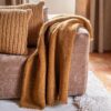 Coussins en laine Chicky et Crispy, coloris Honey, thème Les Rocheuses et plaid en laine et alpaga Molière coloris Caramel thème Sous-bois